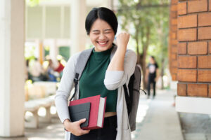 An Asian woman is outdoors and making excited gestures for Leantime version updates. Leantime v2.3 and more.